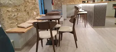 a bar with a row of stools and tables at Xanela Xures in Muiños