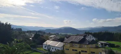 a house on a hill with mountains in the background at Mirador do Xistral in Valle de Oro