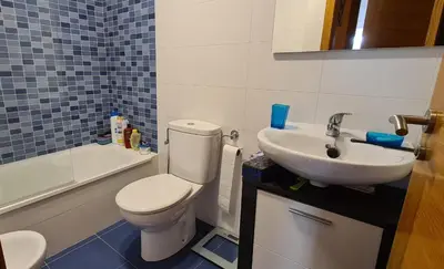 a bathroom with a white toilet and a sink at Mirador do Xistral in Valle de Oro