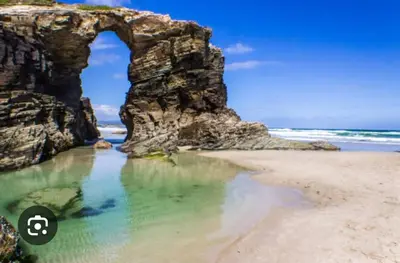 an arch in a rock formation on a beach at Mirador do Xistral in Valle de Oro