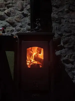a brick oven with a fire in it at cabaña do rei in Betán