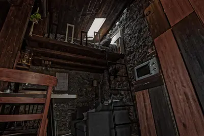 a small room with a staircase and a microwave at cabaña do rei in Betán