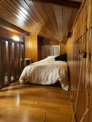 a bedroom with a bed in a wooden wall at A Ribeira in Castro Caldelas