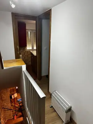 a hallway with a staircase and a heater in a room at A Ribeira in Castro Caldelas
