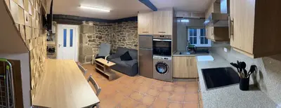 a kitchen with a stove and a couch in a room at A Ribeira in Castro Caldelas