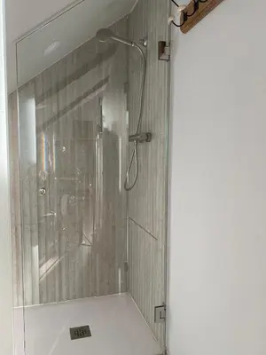 a shower with a glass door in a bathroom at El Balcón del Eume, Cantina Río Covés in Puentedeume