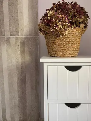a white cabinet with a basket of flowers on it at El Balcón del Eume, Cantina Río Covés in Puentedeume