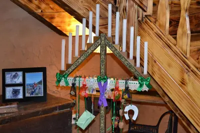 a christmas cross hanging on a wall with candles at El Trasgu de Foncebadón in Foncebadón