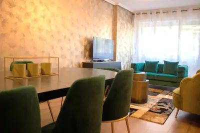 a dining room with a table and green chairs at Golden Home in Ourense