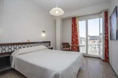 a bedroom with a white bed and a large window at Hotel La Ruta in Tapia de Casariego