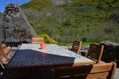 a table and chairs with an umbrella in front of a building at Casas Rurales Las Corradas in Éndriga