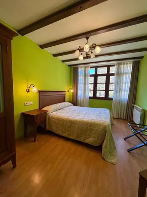 a bedroom with blue walls and a bed and a mirror at Casas Rurales Las Corradas in Éndriga