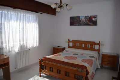 a bedroom with a bed and a dresser and windows at El Molino in Melide