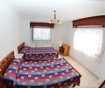 a bedroom with two beds and two windows at El Molino in Melide