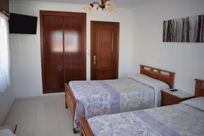 a hotel room with two beds and a window at El Molino in Melide
