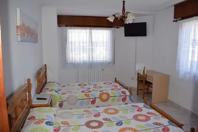 a bedroom with a bed and a desk in it at El Molino in Melide