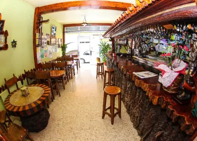 a restaurant with a bar with tables and chairs at El Molino in Melide