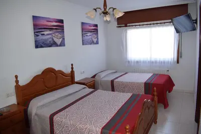 a bedroom with two beds and a window at El Molino in Melide