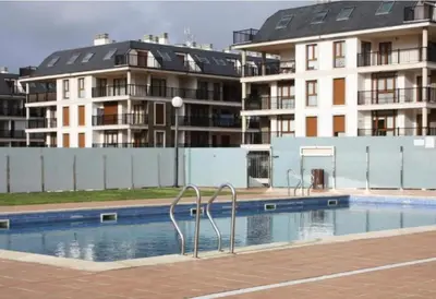 a swimming pool in front of some apartment buildings at Dúplex Entero en Foz in Foz