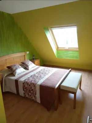 a bedroom with a large bed and a window at Dúplex Entero en Foz in Foz