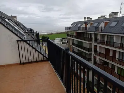 an apartment balcony with a view of a building at Dúplex Entero en Foz in Foz