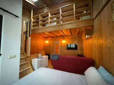 a bedroom with a red couch and a bunk bed at Casa Arroio - Casco antiguo de Allariz in Allariz