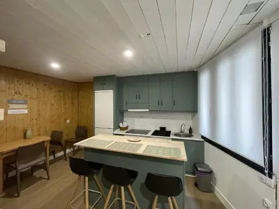 a kitchen with green cabinets and a table and chairs at Casa Arroio - Casco antiguo de Allariz in Allariz
