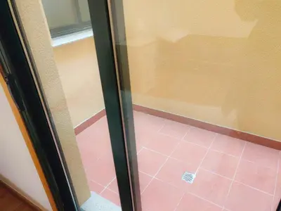 a sliding glass door in a room with a pink tile floor at Costa SPA Terraza de lujo - Playa las Catedrales in San Miguel de Reinante