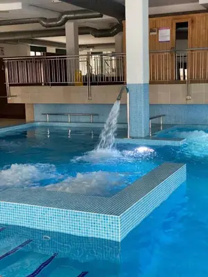 a swimming pool with a fountain in a building at Costa SPA Terraza de lujo - Playa las Catedrales in San Miguel de Reinante