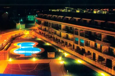 arial view of a building with a swimming pool at night at Costa SPA Terraza de lujo - Playa las Catedrales in San Miguel de Reinante