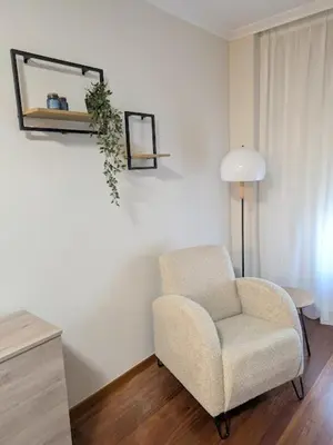 a living room with a chair and a mirror at O Pisiño de Andrés in Caldas de Reis