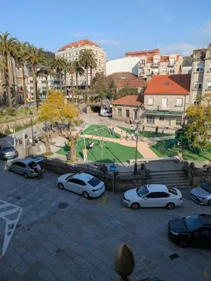 a group of cars parked in a parking lot with a park at O Pisiño de Andrés in Caldas de Reis