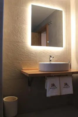 a bathroom with a sink and a mirror at Hotel Miralrio Cacabelos in Cacabelos