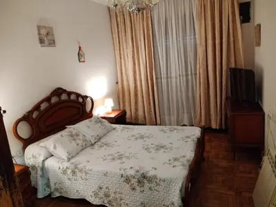 a bedroom with a bed and a window with curtains at Casa Albergue PTY in Sarria