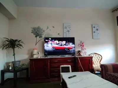a living room with a tv on a wooden entertainment center at Casa Albergue PTY in Sarria
