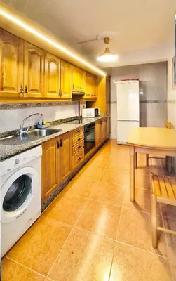 a kitchen with a washing machine and a table at Apartamento en Betanzos in Betanzos