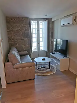 a living room with a couch and a tv at O Lar do Rodrigo in Castro Caldelas
