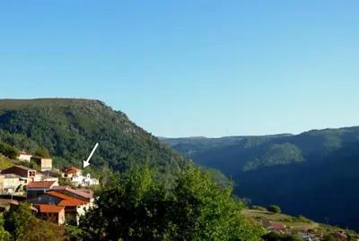 a small village on a hill with mountains in the background at Casa en la Ribeira Sacra, Pombeiro in Lago