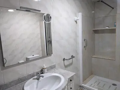 a white bathroom with a sink and a shower at Casa Cancelas in Santiago de Compostela