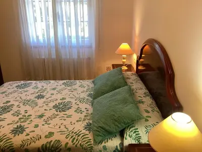 a bedroom with a bed with a blanket and a lamp at Casa Cancelas in Santiago de Compostela