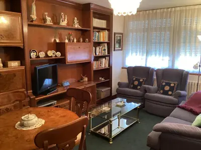 a living room with a table and chairs and a television at Casa Cancelas in Santiago de Compostela