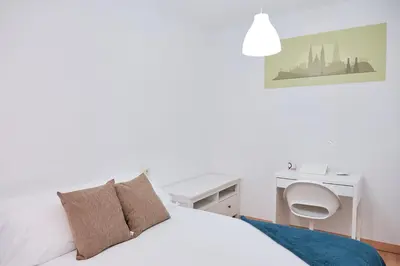 a white bedroom with a desk and a bed at 9Estudio Sightviews in Santiago de Compostela