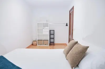 a bedroom with a white bed and a closet at 9Estudio Sightviews in Santiago de Compostela
