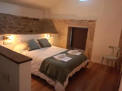 a bedroom with a bed with two towels on it at Ao Carón do Camiño in Padrón