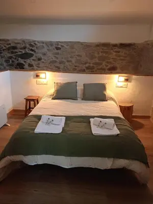 a bedroom with a large bed with towels on it at Ao Carón do Camiño in Padrón