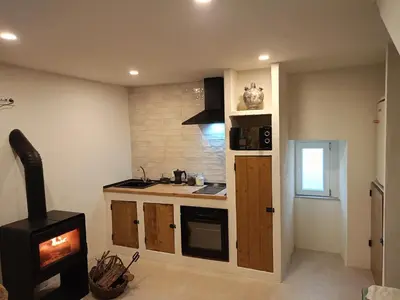 a kitchen with a stove and a sink and a stove at Ao Carón do Camiño in Padrón