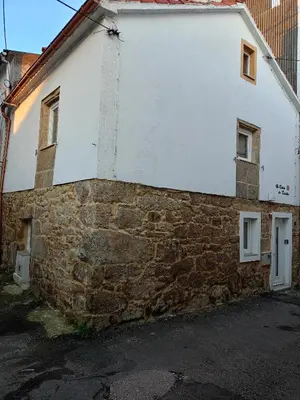 an old stone building with two windows on it at Ao Carón do Camiño in Padrón
