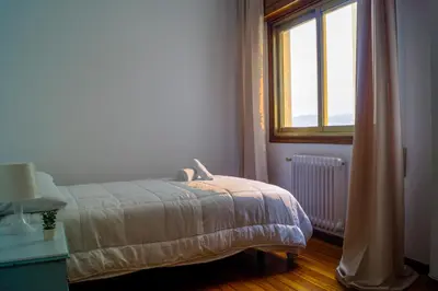 a bedroom with a bed next to a window at YourHouse Progreso 1 apartment in Ourense