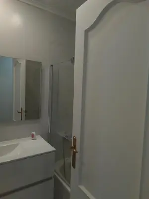 a white bathroom with a shower and a sink at A Pia da Moura in Ourense