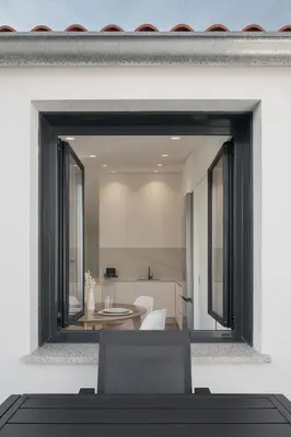 a mirror on a wall with a dining room at Avós Apartamentos in Monforte de Lemos